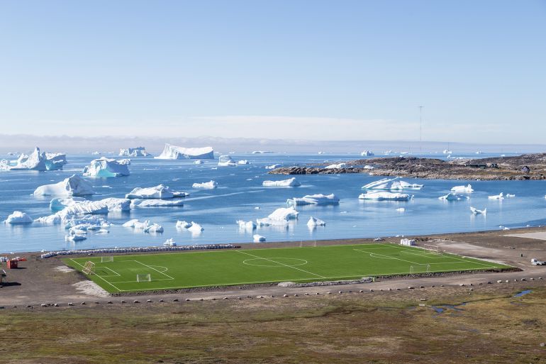 Qeqertarsuaq, Greenland July 6, 2018: The local soccer field with icebergs in the background